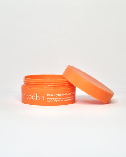 Orange skincare mbodhii Rose Hydration Face Cream jar with an open lid on a white background