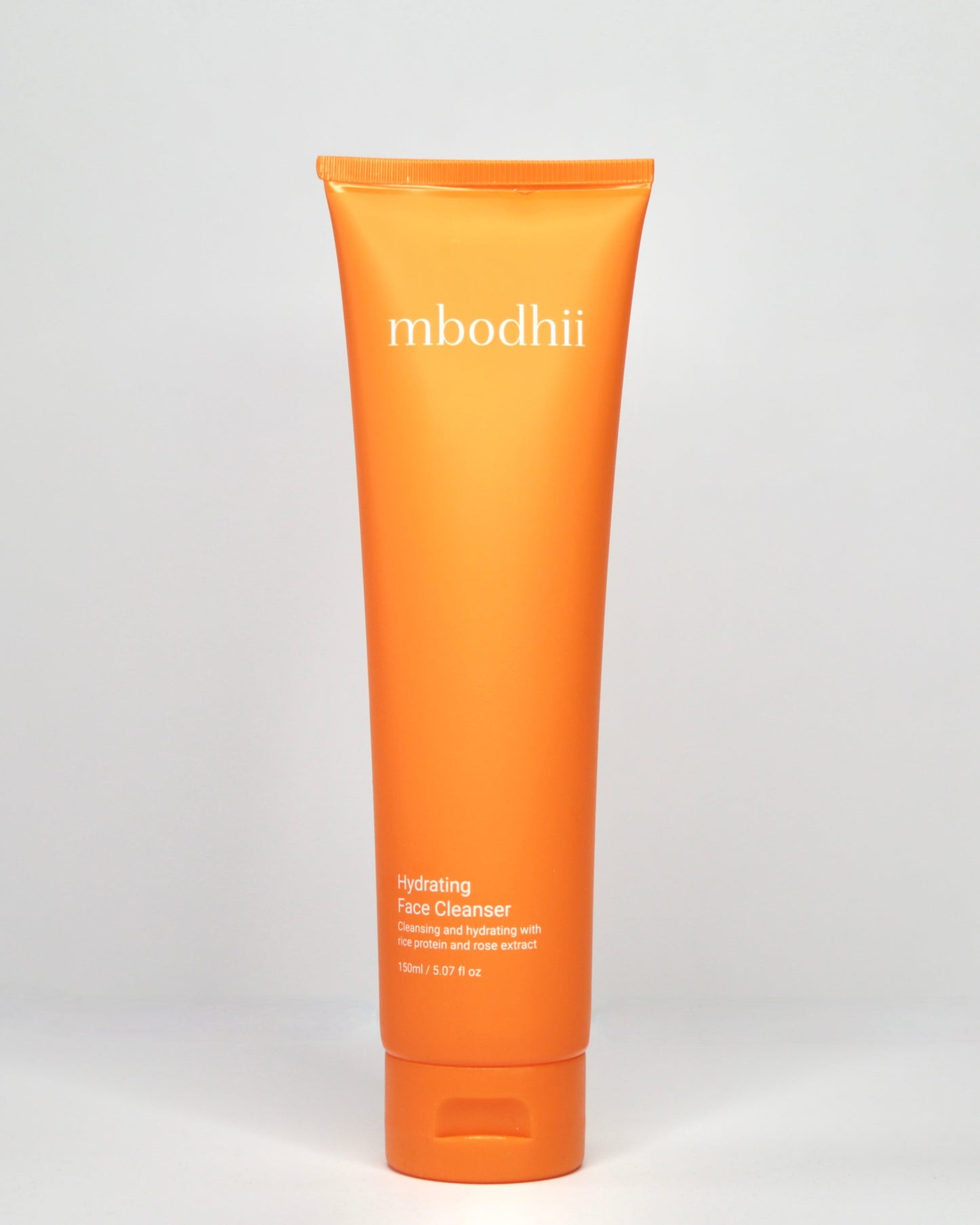 mbodii Hydrating Face Cleanser in an orange tube on a white background