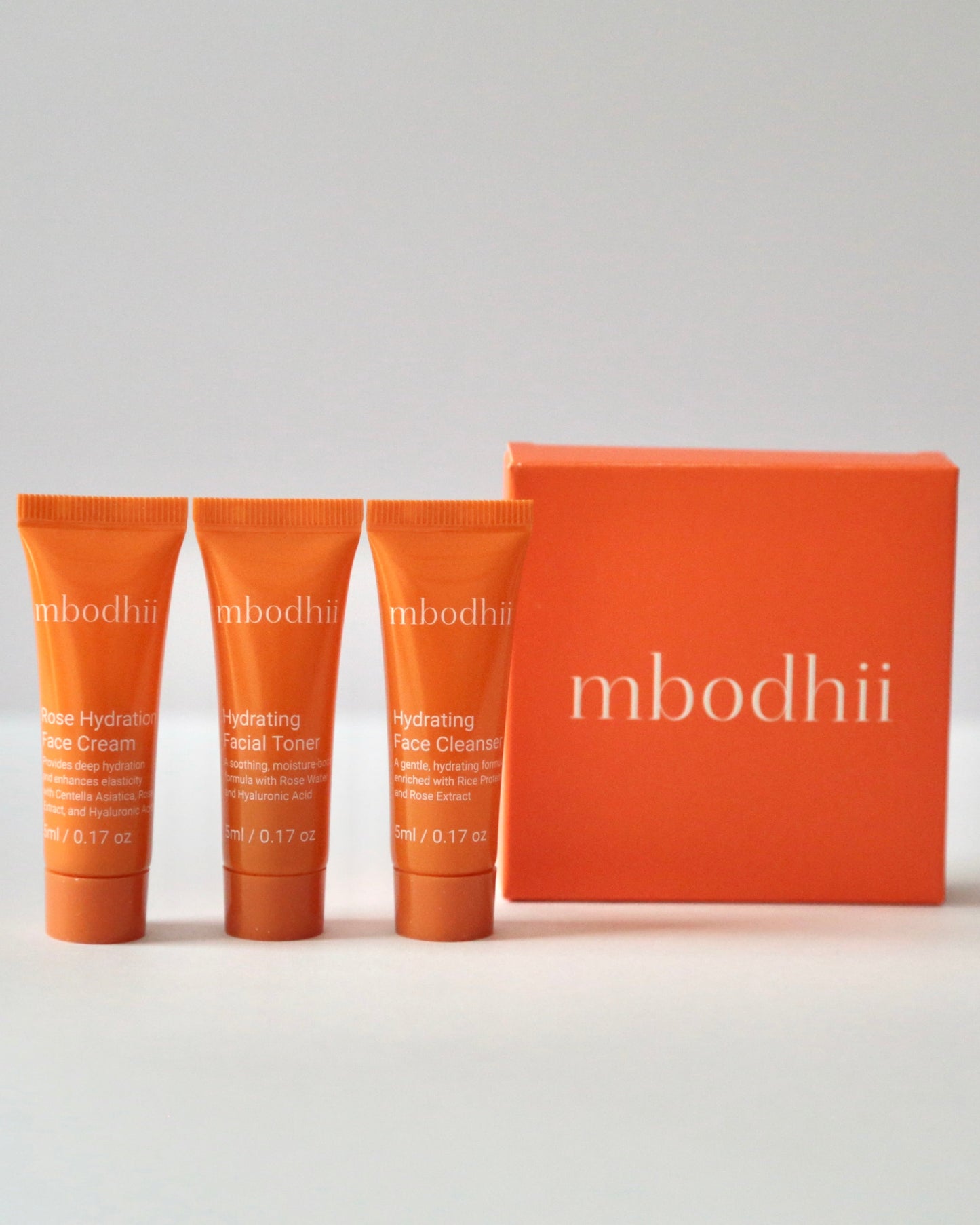 The mbodhii Mini Sample pack featuring 5 ml each of the Rose Hydration Face Cream + Hydrating Facial Toner + Hydrating Face Cleanser with it's travel box on a white background.